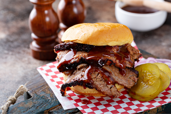Smoked barbecue beef brisket sandwich with pickles and bbq sauce