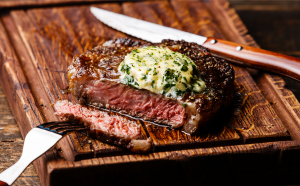 Grilled Medium rare steak Ribeye with herb butter on cutting board serving size